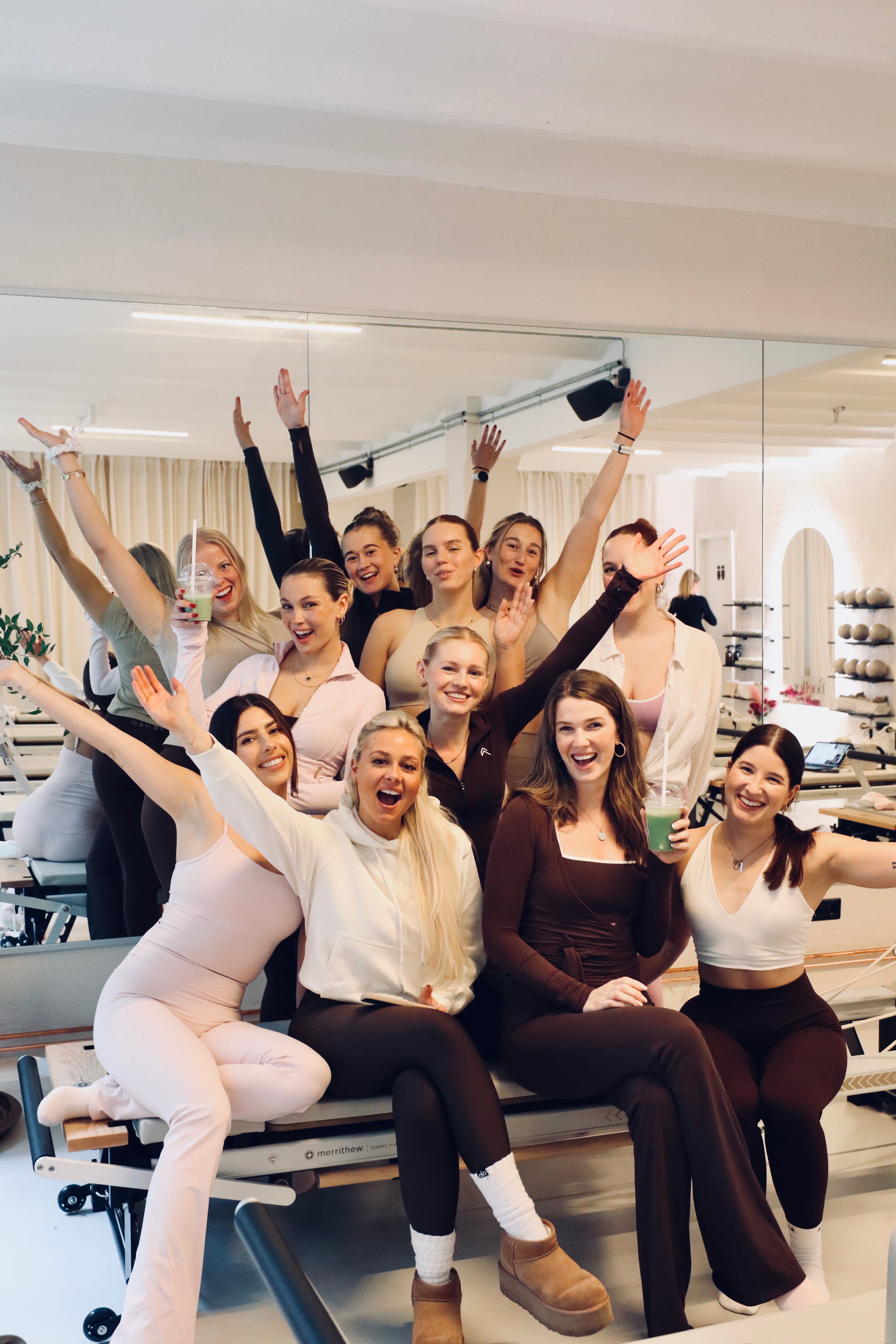 Beim Baetter Event in einem Pilatesstudio strecken Jo und ihre Freundinnen vor Freude die Hände in die Luft und winken zur Kamera